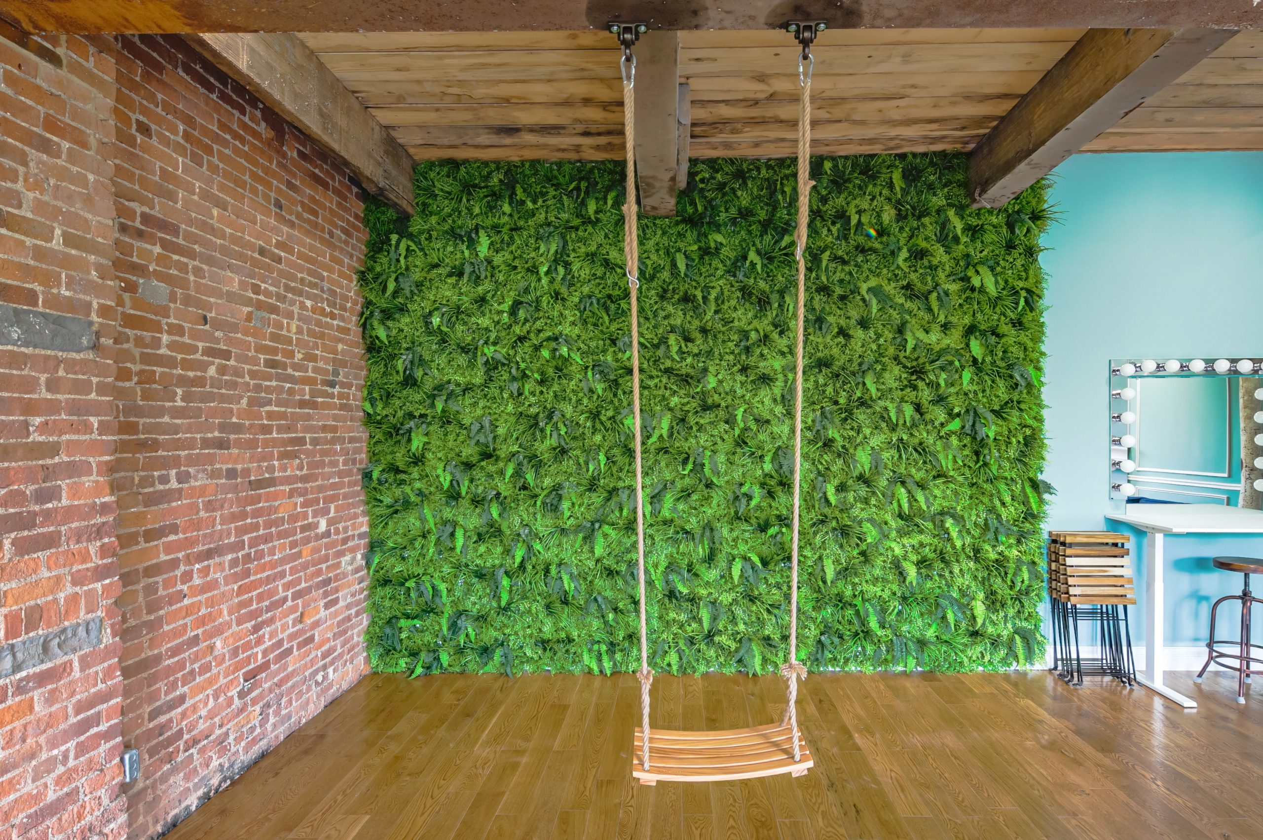 swing in a fern filled wall in a photo studio