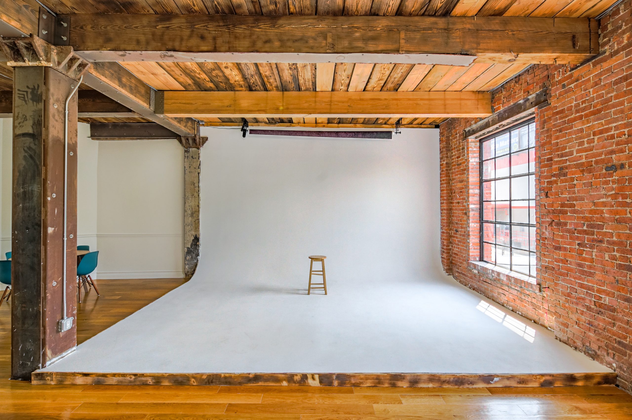 wooden chair in the middle of a white cyclorama in a photo studio